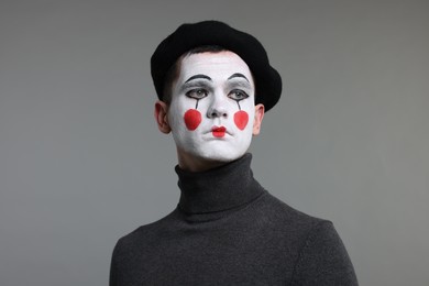 Portrait of mime artist in beret on grey background