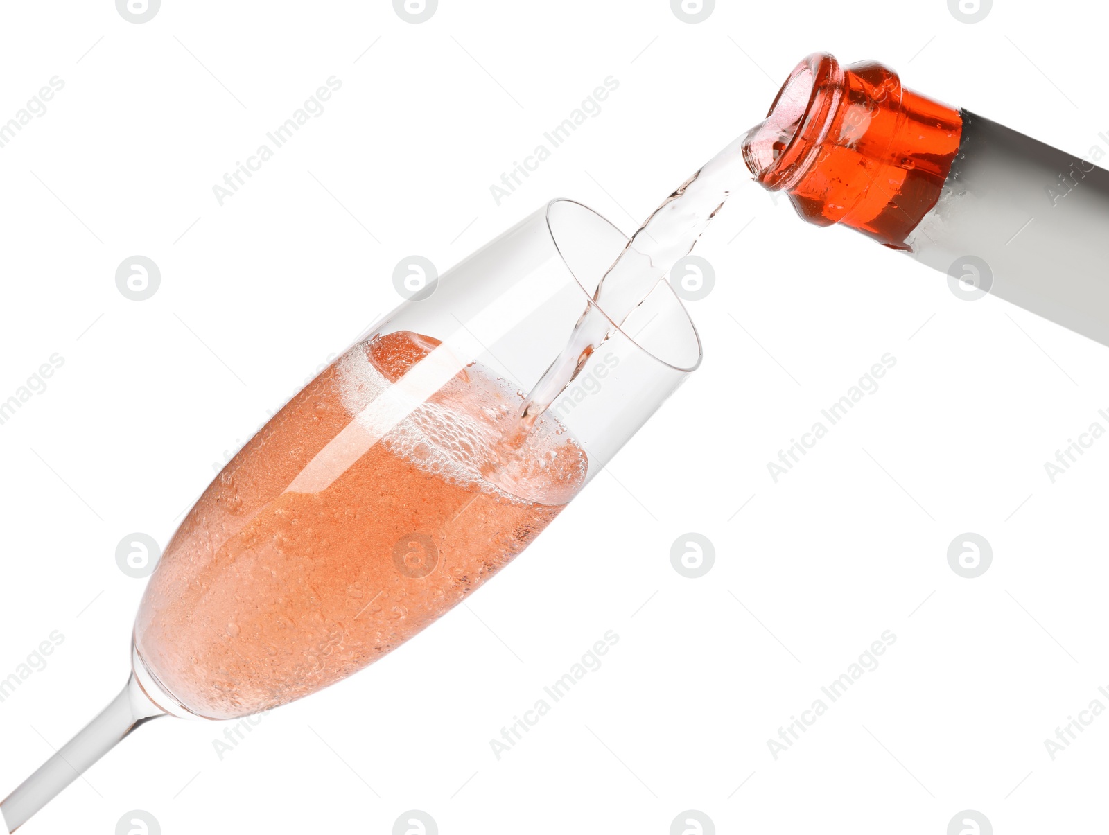 Photo of Rose champagne pouring from bottle into glass isolated on white