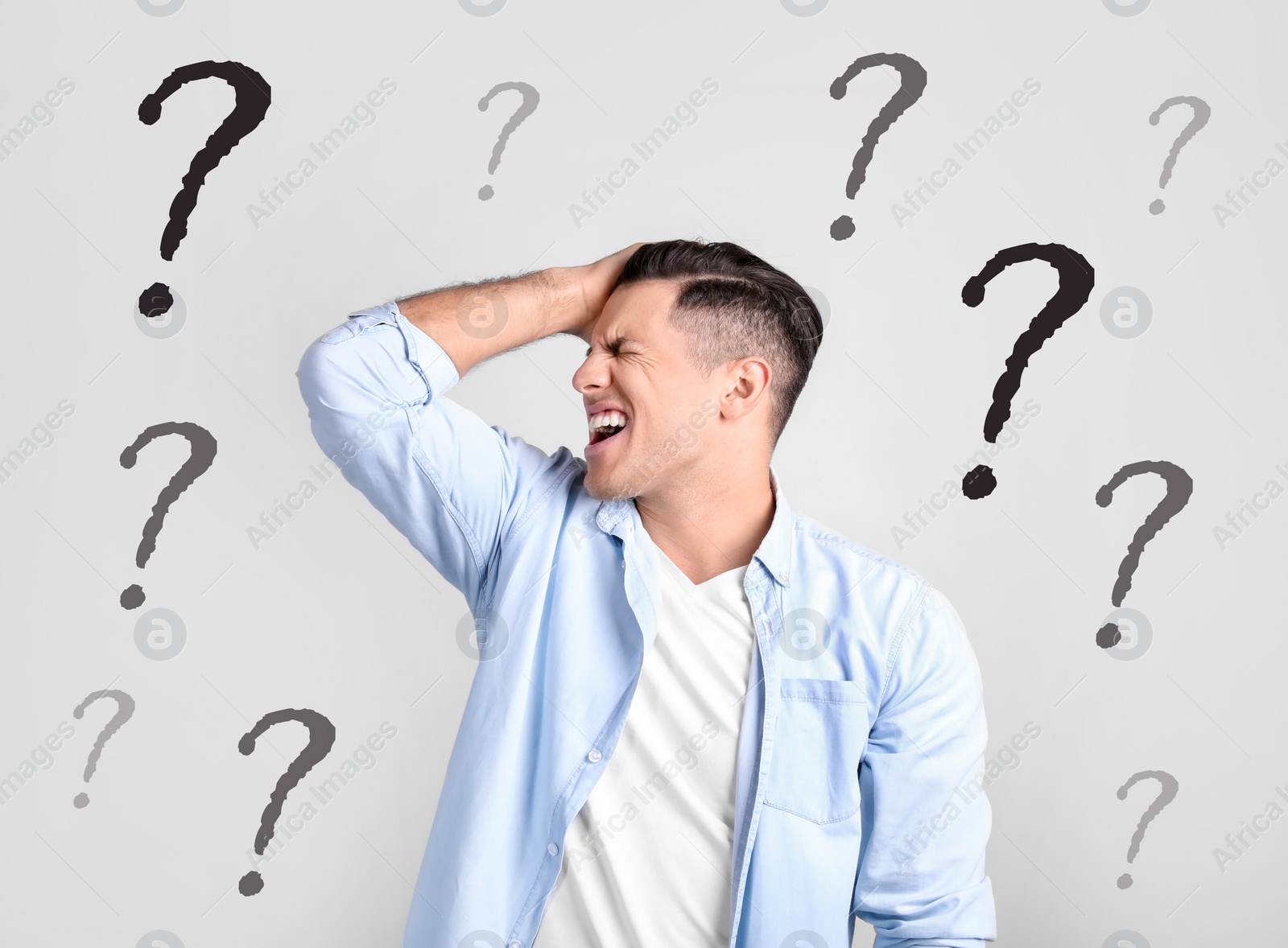 Image of Amnesia. Stressed man and question marks on light background