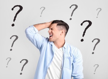 Image of Amnesia. Stressed man and question marks on light background