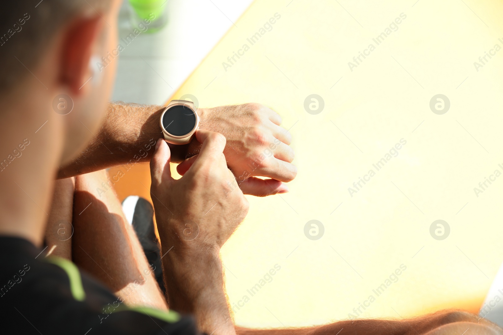 Photo of Man checking fitness tracker in gym, closeup. Space for text