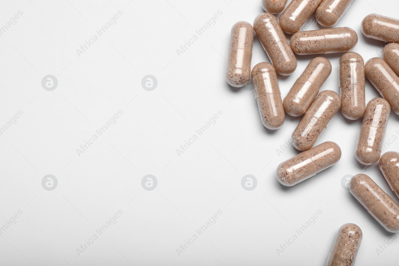 Photo of Many transparent gelatin capsules on white background, top view