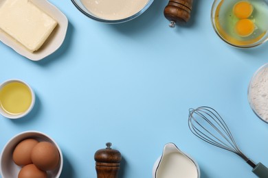 Photo of Frame made of dough ingredients and whisk on light blue background, flat lay. Space for text