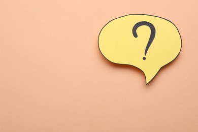 Paper speech bubble with question mark on beige background, top view. Space for text