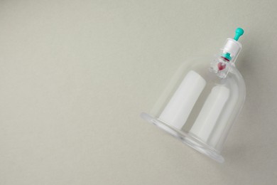 Photo of Plastic cup on light grey background, top view with space for text. Cupping therapy