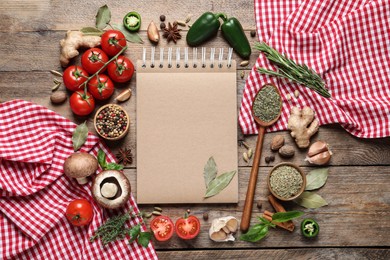 Open recipe book and different ingredients on wooden table, flat lay. Space for text