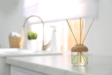 Aromatic reed air freshener on light table indoors. Space for text