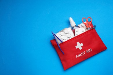 Photo of First aid kit on light blue background, top view and space for text