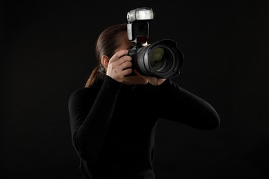 Professional photographer taking picture on black background