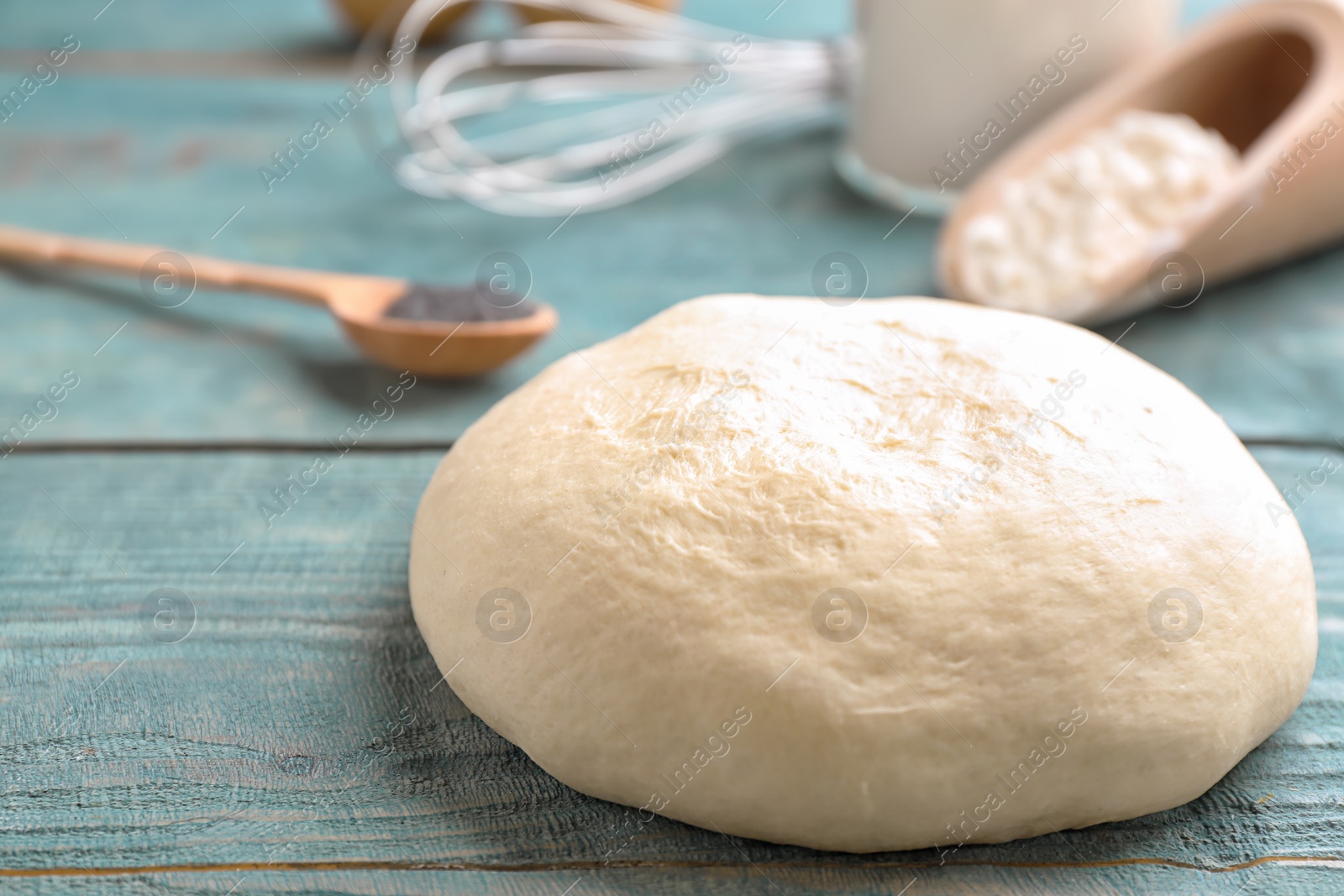 Photo of Fresh raw dough on wooden table