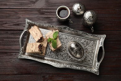 Photo of Tasty chocolate halva served on wooden table, flat lay