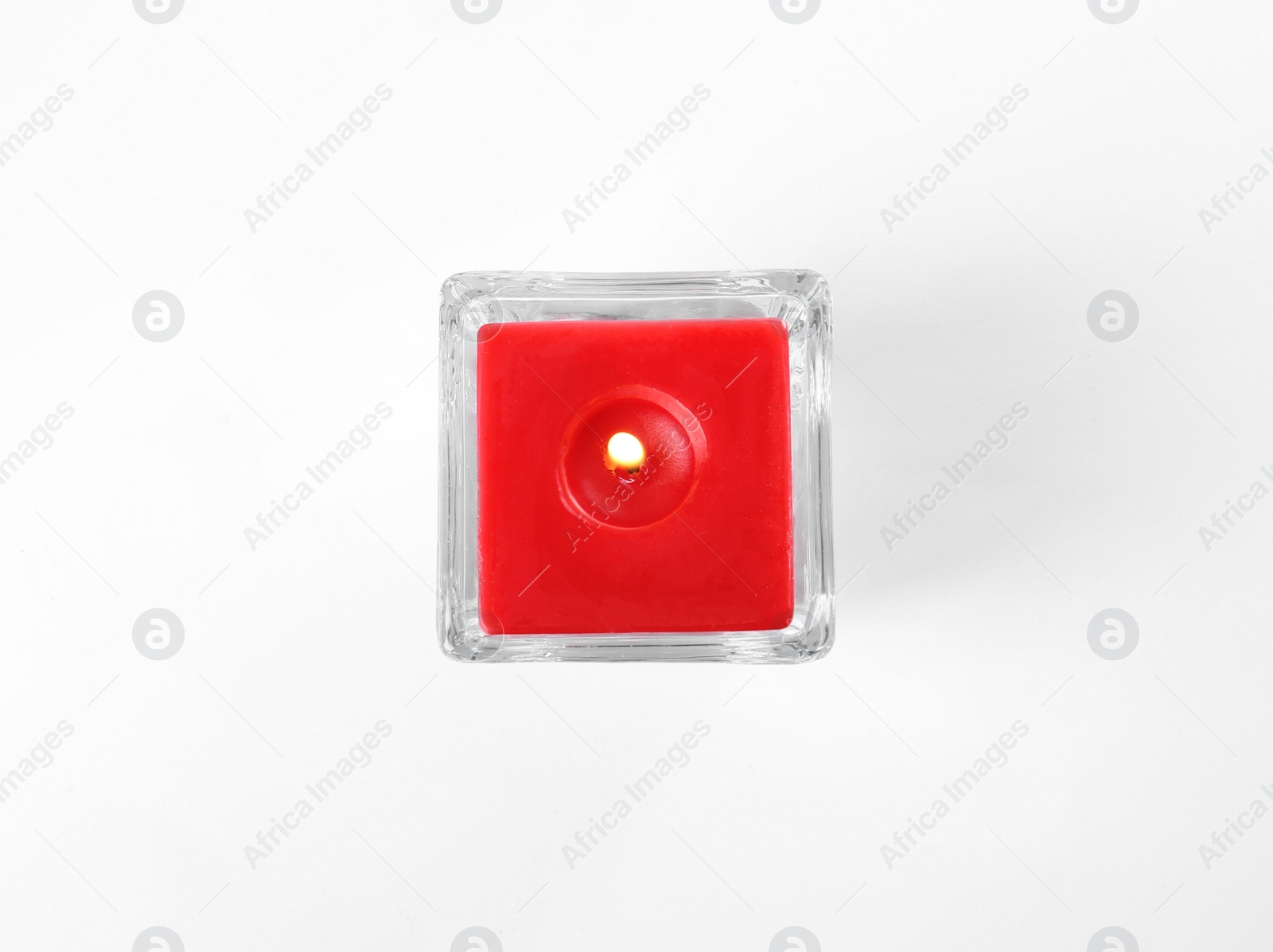 Photo of Burning candle in glass holder isolated on white, top view