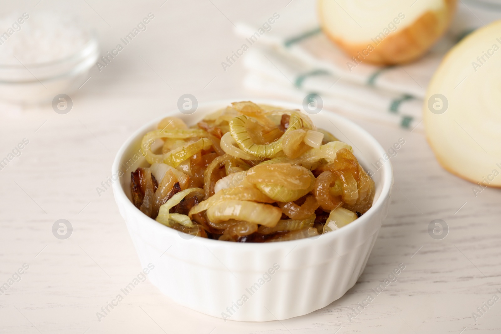 Photo of Tasty fried onion in bowl on white table
