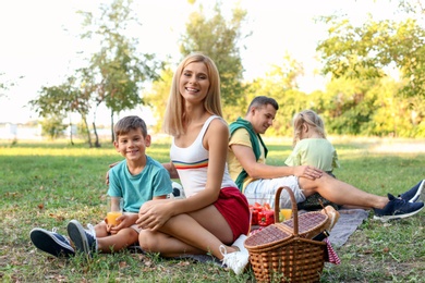 Photo of Happy family having picnic in park on sunny day