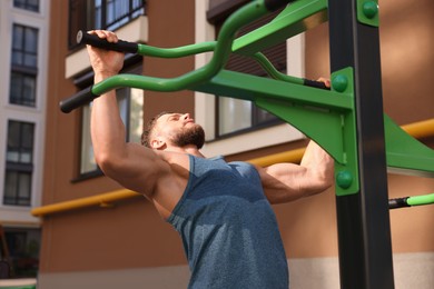 Photo of Man doing pull ups at outdoor gym
