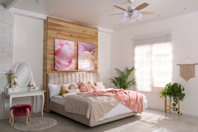 Photo of Stylish room interior with large comfortable bed and beautiful paintings