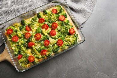 Photo of Tasty broccoli casserole in baking dish on grey table, top view