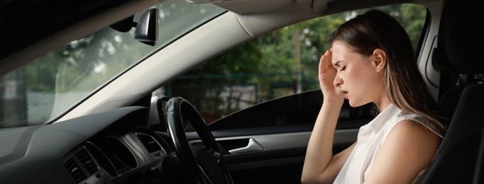 Tired young woman driver's seat of modern car. Banner design