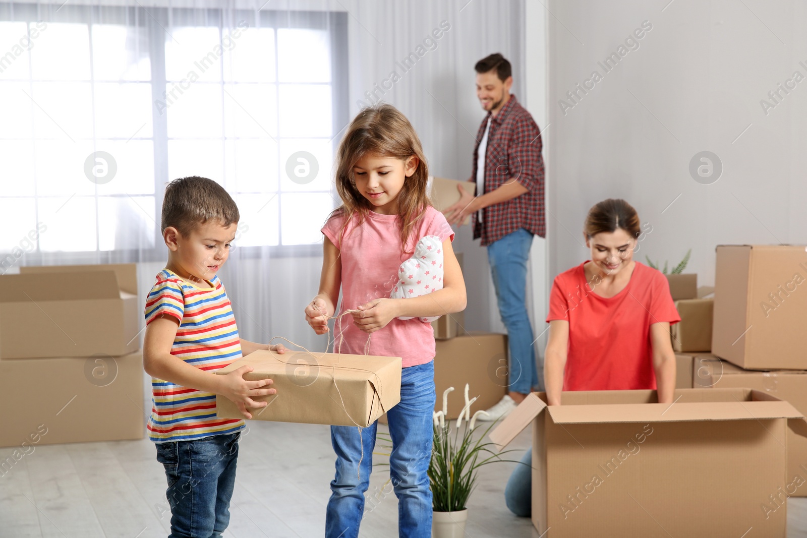 Photo of Happy family unpacking boxes in their new house. Moving day