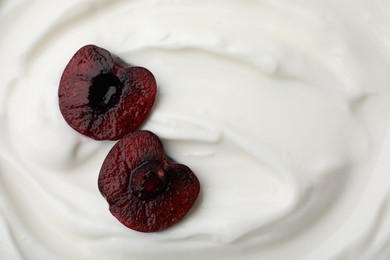 Tasty yogurt with cut cherry as background, top view. Space for text