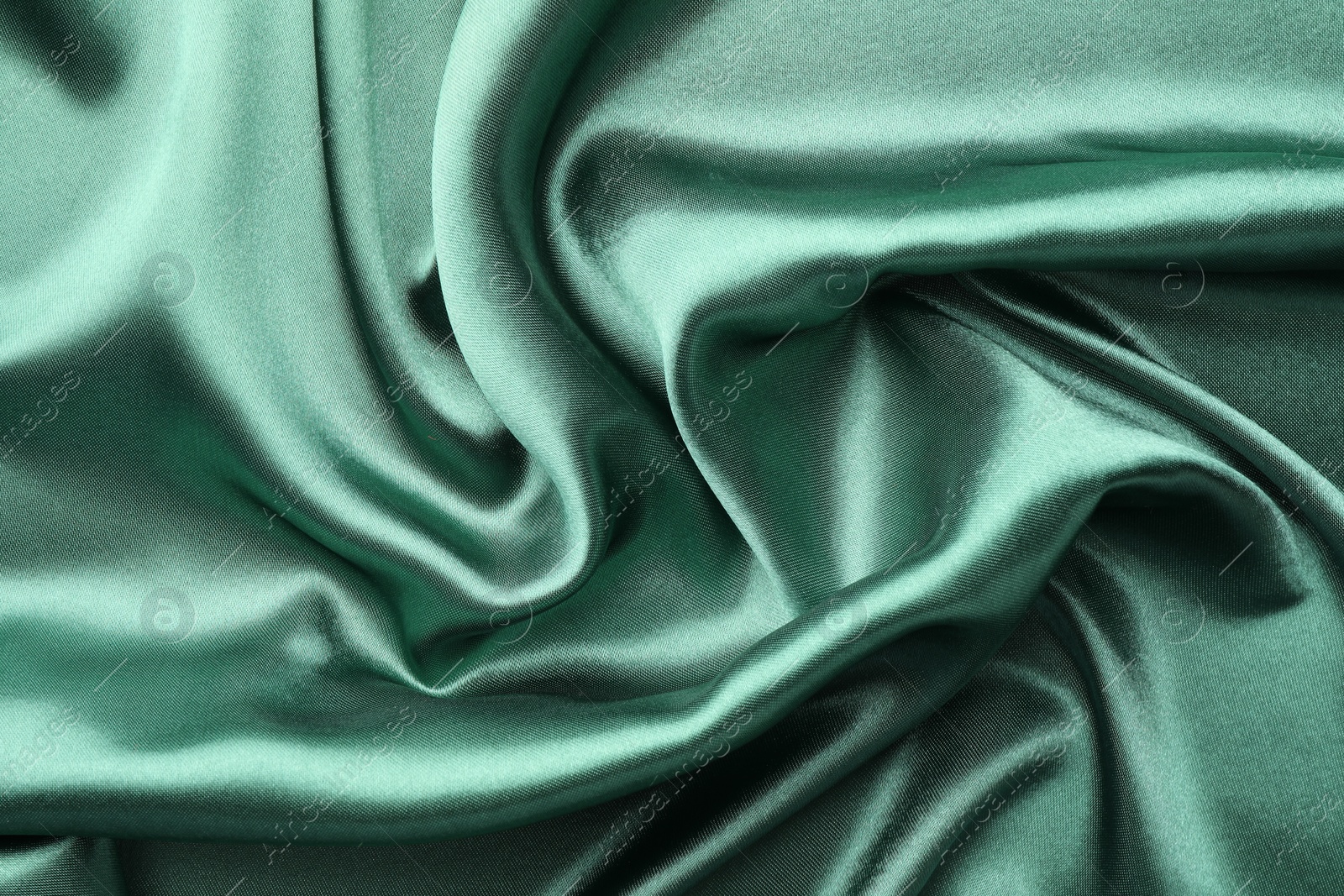 Photo of Crumpled green silk fabric as background, top view