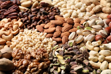 Photo of Organic mixed nuts as background, closeup. Healthy snack