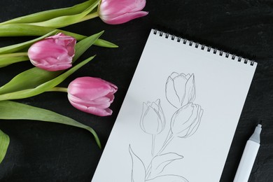 Photo of Sketch of tulips in notebook and flowers on black table, flat lay