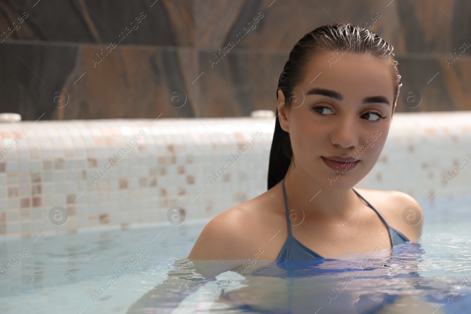 Photo of Beautiful woman in spa swimming pool, space for text