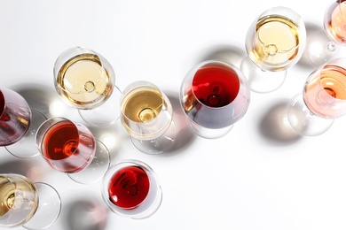 Different glasses with wine on white background, top view