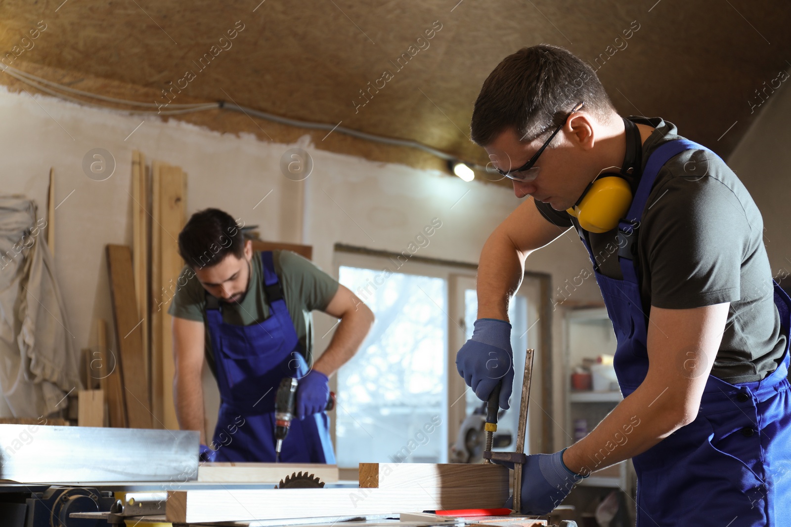 Photo of Professional carpenters working with wood in shop