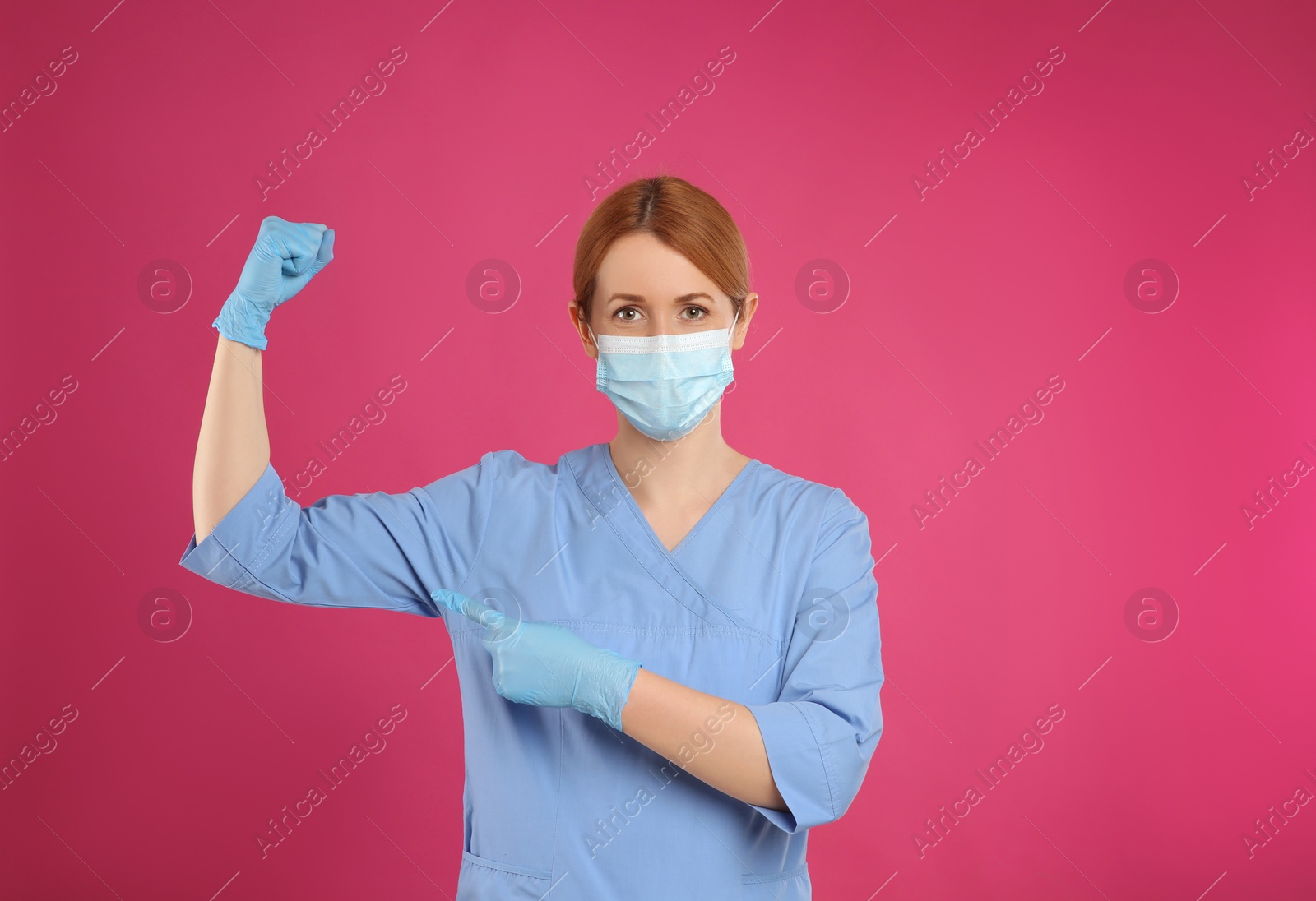 Photo of Doctor with protective mask showing muscles on pink background, space for text. Strong immunity concept
