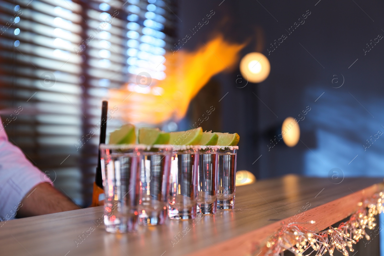 Photo of Mexican Tequila shots with lime slices on bar counter