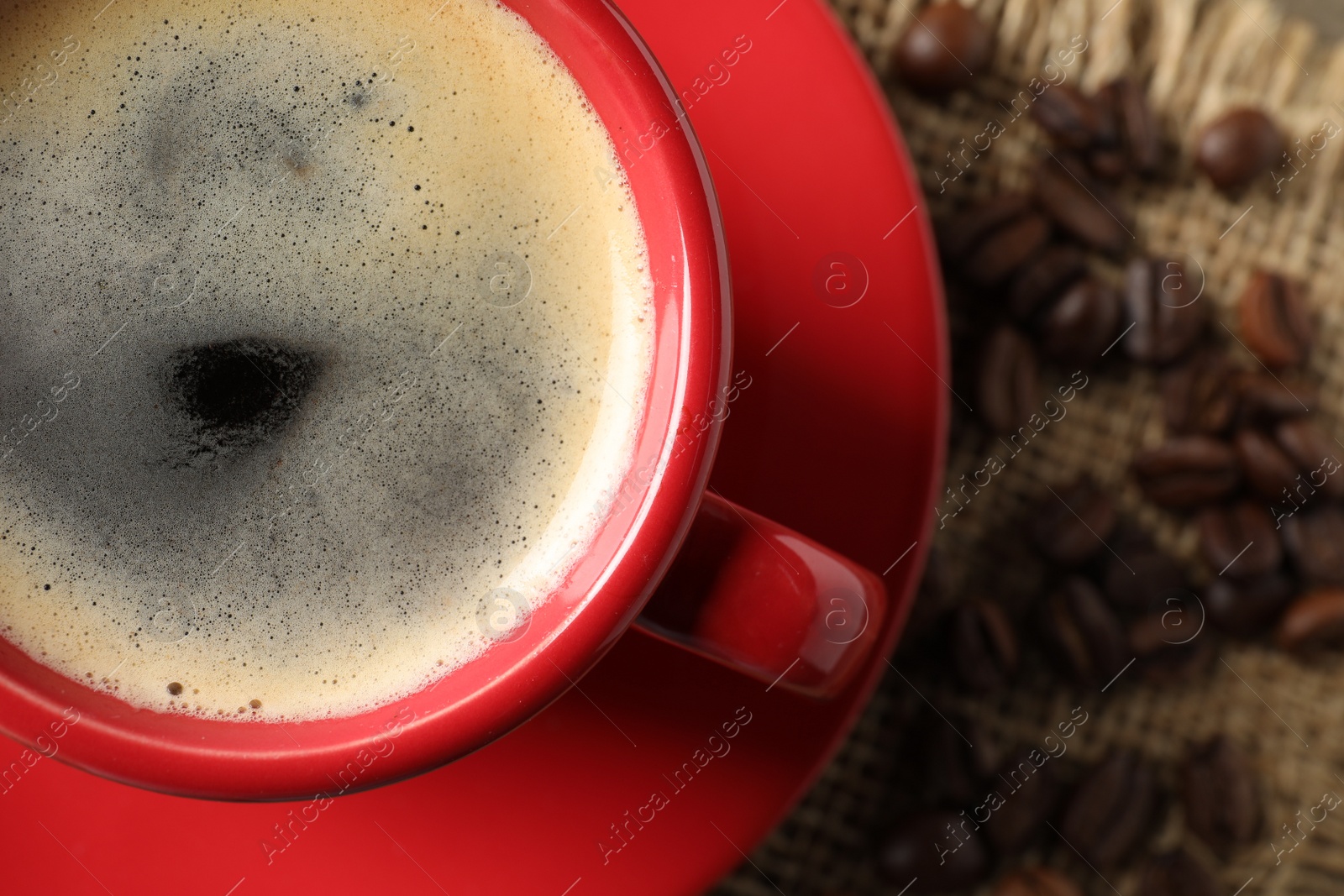 Photo of Cup of aromatic coffee on wooden table, top view. Space for text