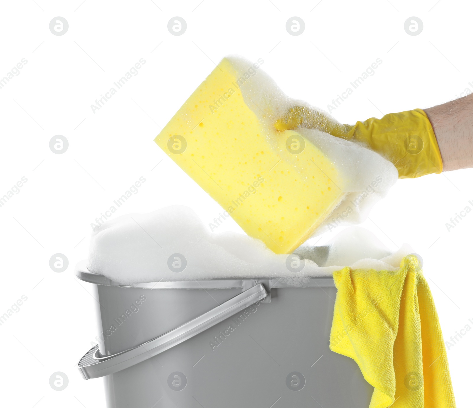 Photo of Man holding sponge over bucket with foam on white background, closeup. Cleaning supplies