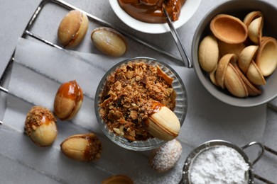 Delicious walnut shaped cookies with condensed milk on grey table, flat lay