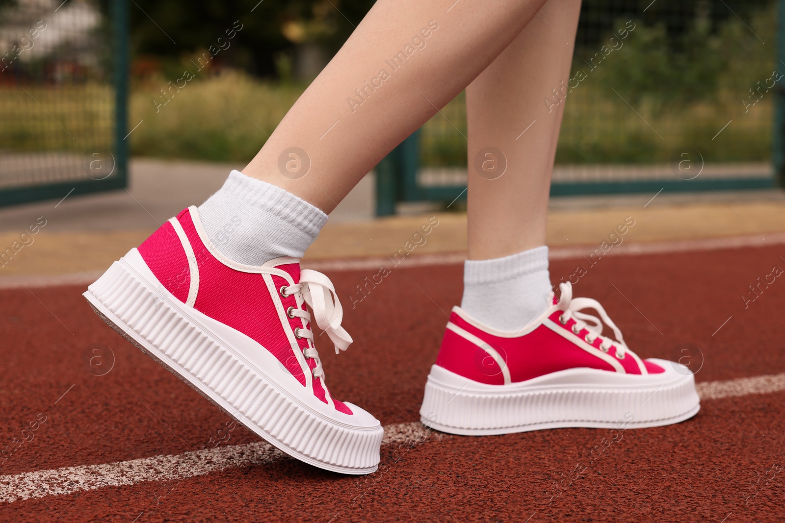 Photo of Woman wearing classic old school sneakers on sport court outdoors, closeup