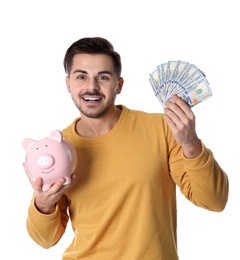 Young man with money and piggy bank on white background