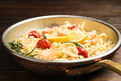 Photo of Delicious pasta with shrimps on wooden table