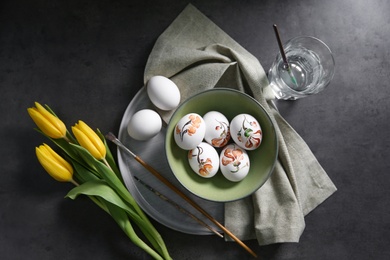 Photo of Flat lay composition with painted Easter eggs on dark table