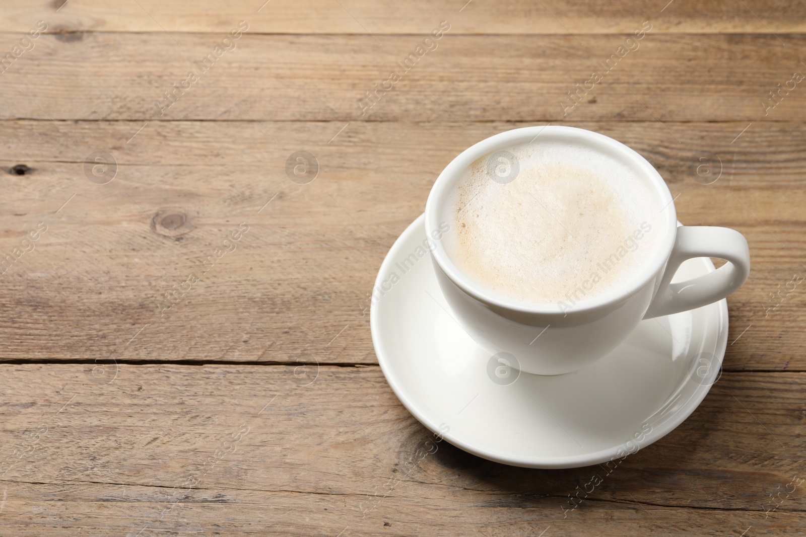 Photo of Cup of aromatic coffee on wooden table. Space for text