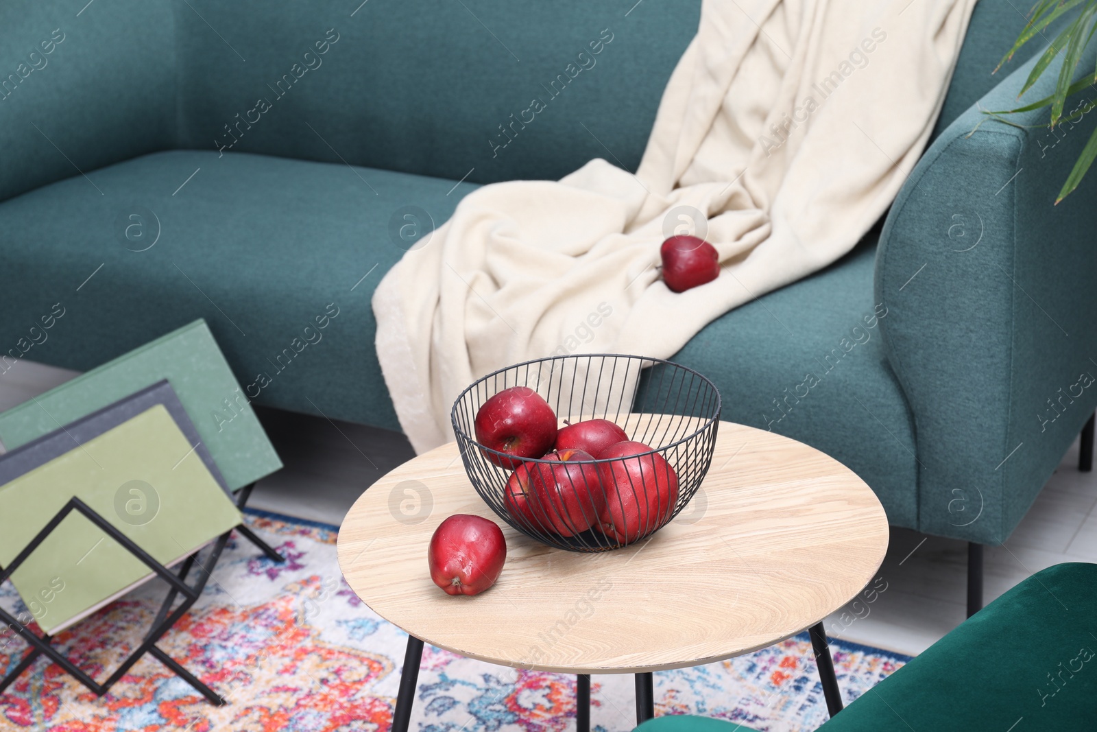 Photo of Red apples on side table near sofa in living room
