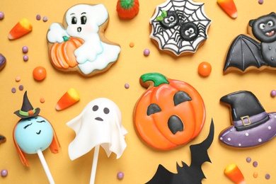 Photo of Different decorated gingerbread cookies on yellow background, flat lay. Halloween celebration