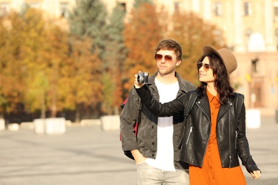 Couple of travelers with camera on city street