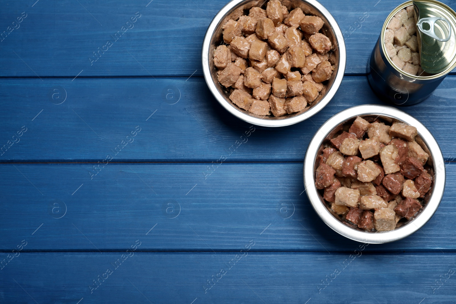 Photo of Wet pet food on blue wooden table, flat lay. Space for text
