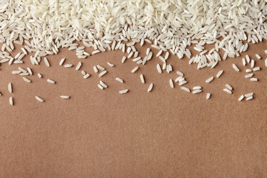 Photo of Long grain rice on color background, top view with space for text