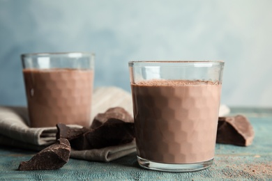 Photo of Glasses with tasty chocolate milk on wooden table. Dairy drink