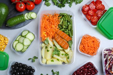 Set of plastic containers with fresh food on light table, flat lay