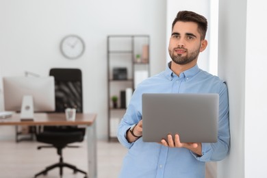 Young programmer working with laptop in office