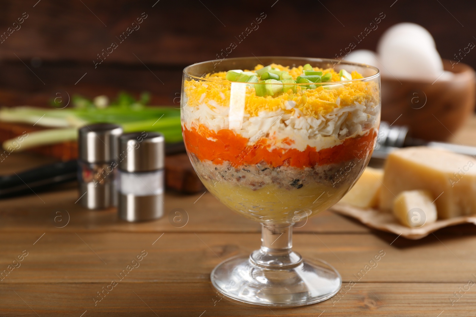 Photo of Traditional russian salad Mimosa served on wooden table