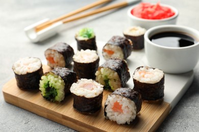 Tasty sushi rolls served on grey table, closeup